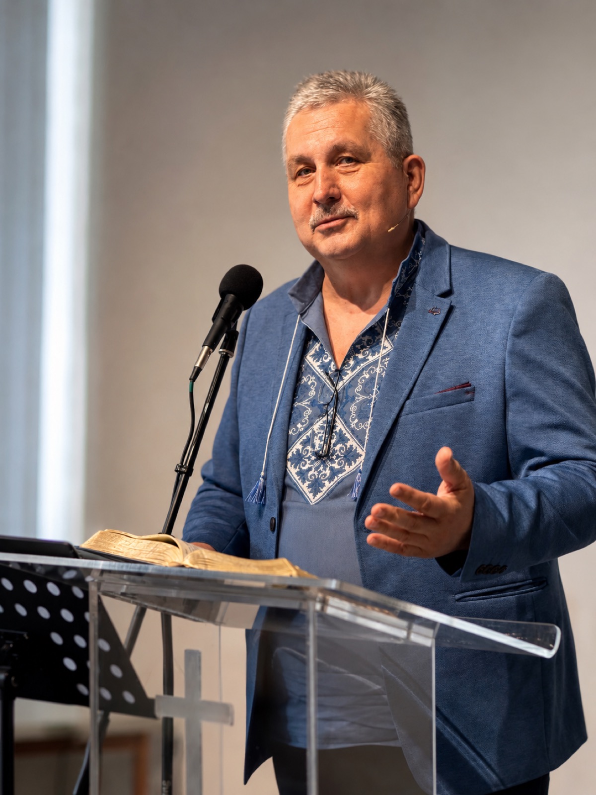Pastor Pavlo Khyzhniak in an embroidered shirt, preaching