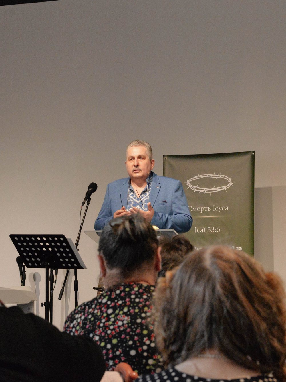 The pastor preaching at the Sunday service, people listening in the hall